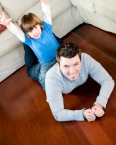 man and child lying on the hardwood floor in a Vancouver home