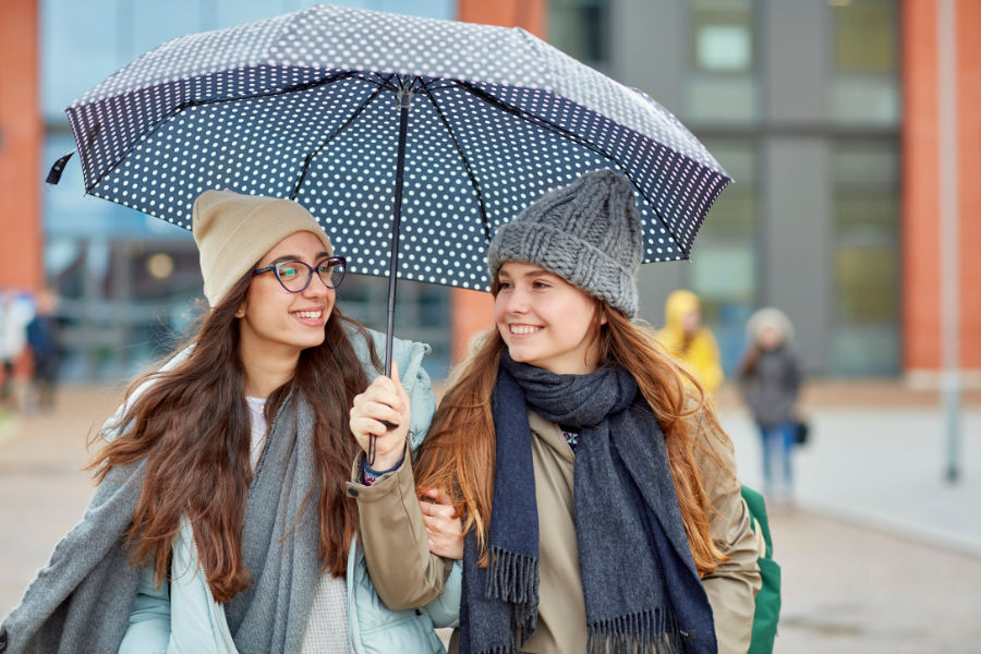 Two students under an umbrella