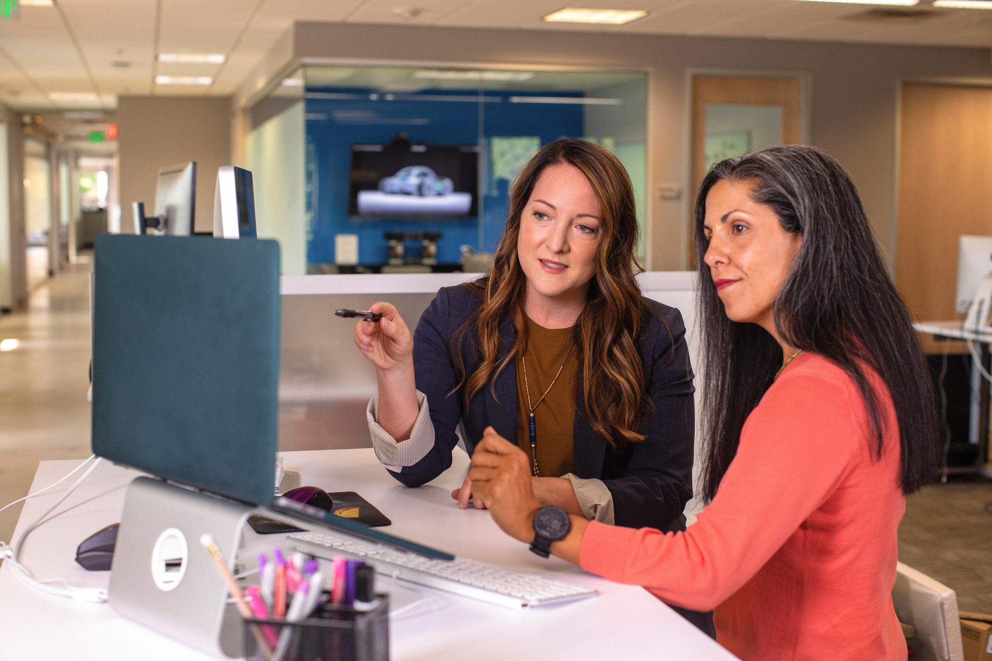 The digital marketing agency's manager and her client discuss webdesign options in the client's office.