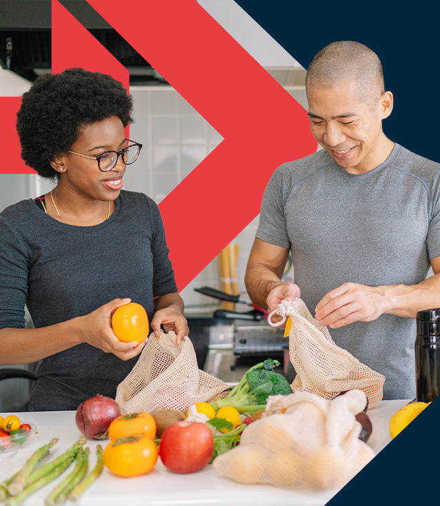 Precision Nutrition Level 1 Coach, discussing nutrition with a client while standing around vegetables in a grocery store