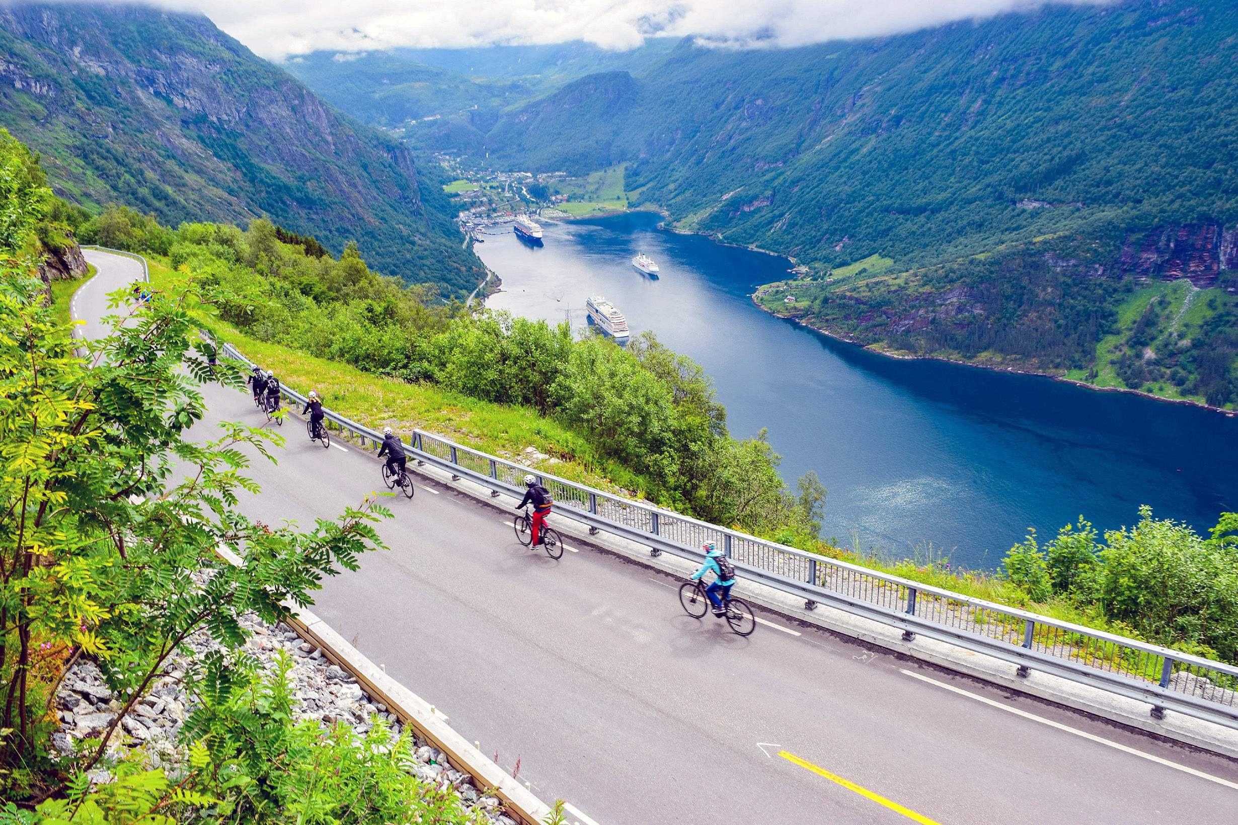 Group of cyclists riding down Eagles Road, Norway