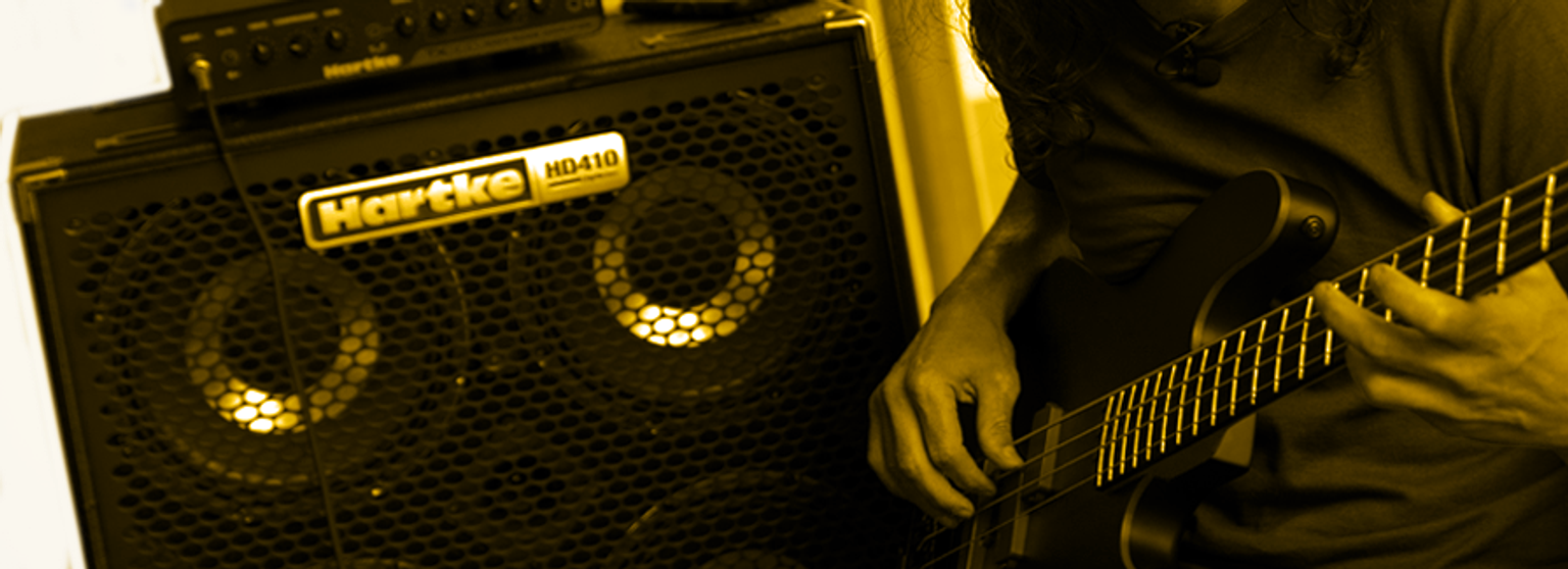 An image of a Harke HD410 and a perons playing a bass guitar