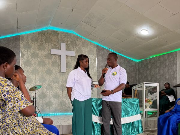Two Foundation team members speak to participants in the Youth Centre hall