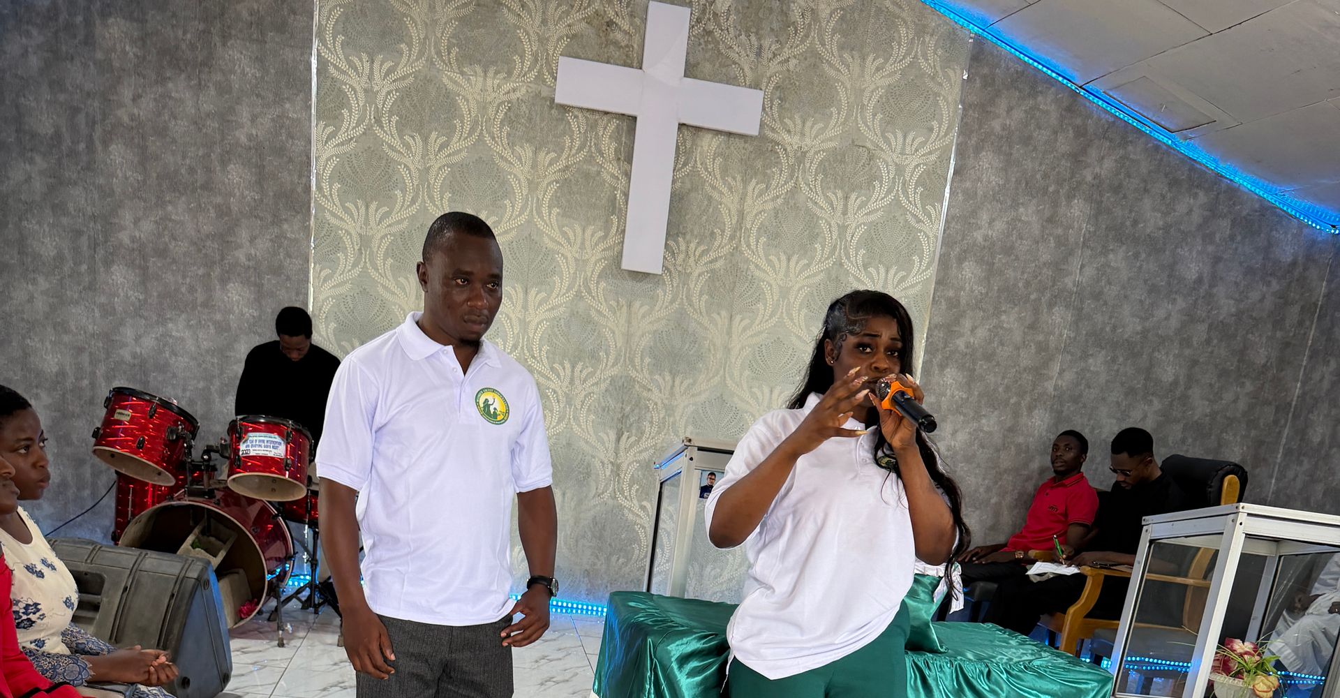 A Foundation team member speaks into a microphone to an audience in the Youth Centre hall