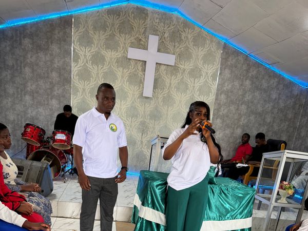 A Foundation team member speaks into a microphone to an audience in the Youth Centre hall