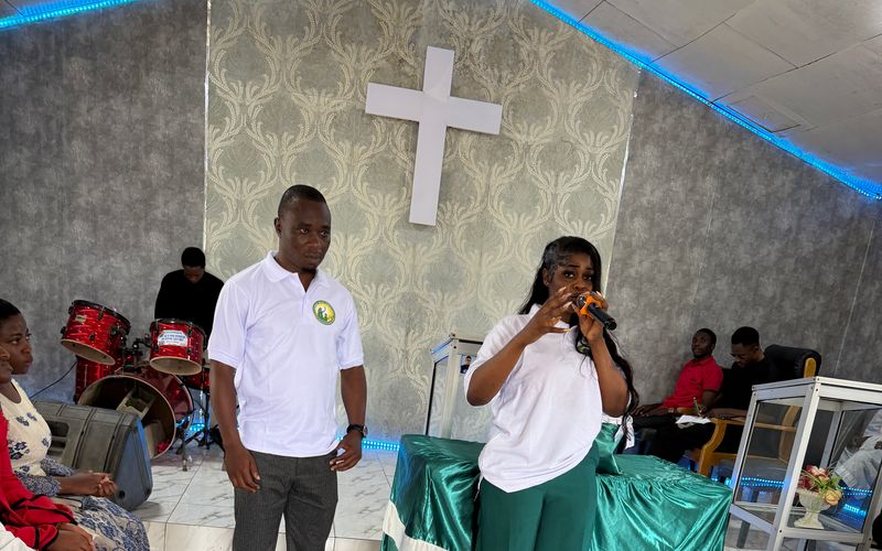 A Foundation team member speaks into a microphone to an audience in the Youth Centre hall