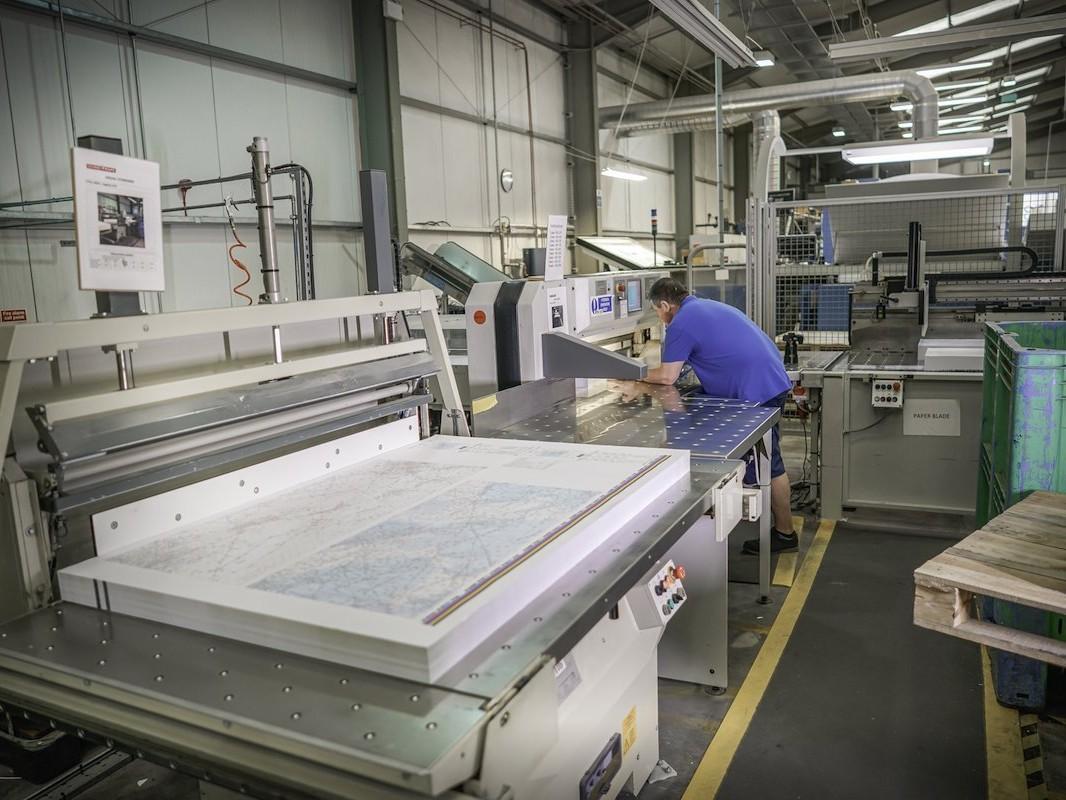 Dennis Maps - map printing people. Man using Schneider Guillotine