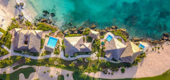 Panoramic aerial view of Eden Roc Cap Cana resort with white sand beach, turquoise waters, and golf course in Punta Cana