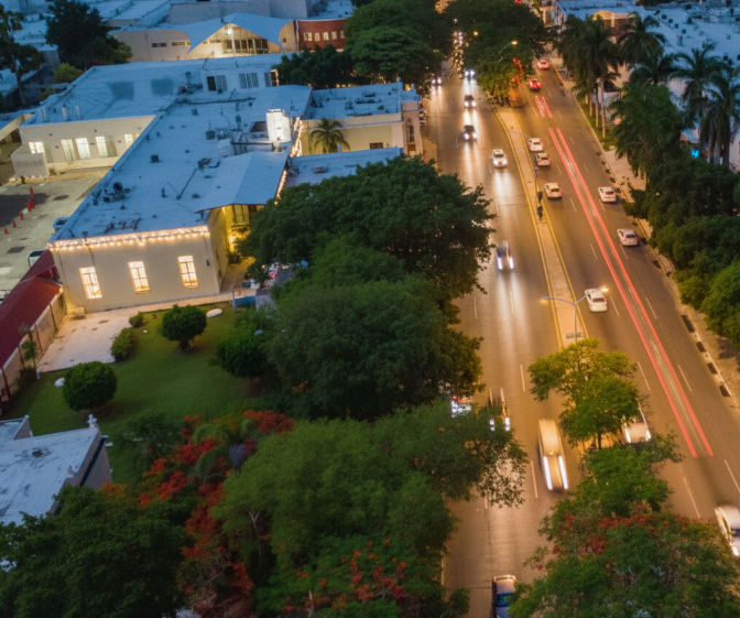Vista de la Avenida Itzáes en Mérida, mostrando el flujo vehicular y su importancia como arteria principal de la ciudad.