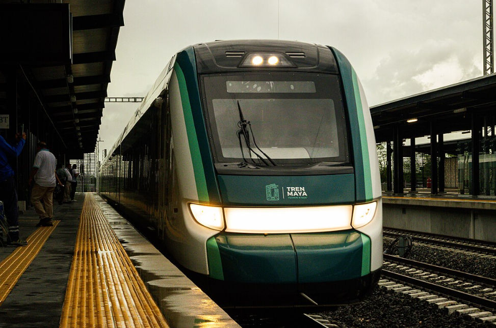 Tren Maya pasando por una zona arqueológica, con turistas observando