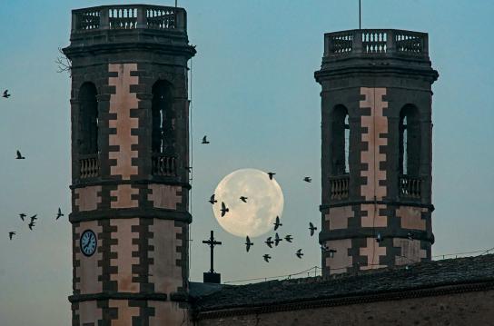 Mira cómo la luna se encaja entre los campanarios gemelos de la iglesia de Olost