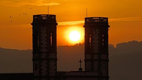 La salida del sol entre los campanarios de Olost