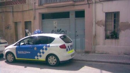 Un coche de la Guàrdia Urbana de Badalona obstaculiza la entrada de un garaje señalizado como vado permanente&nbsp;