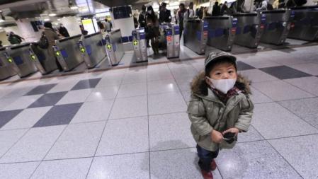 Un niño con mascarilla antes de subir a bordo de un 