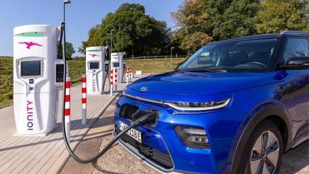Un coche eléctrico recargándose en una estación con varios puntos de conexión