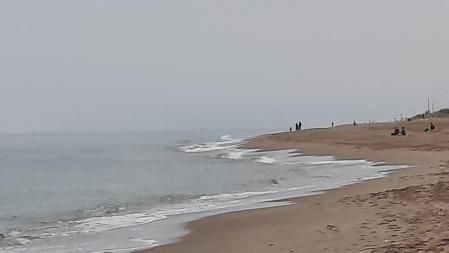 La niebla hace desaparecer el macizo del Garraf, en una perspectiva vista desde la playa de Gavà.