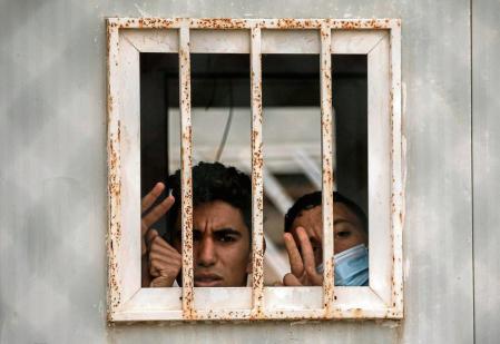 GRAF2247. CEUTA, 20/05/2021.- Dos menores saludan por una ventana del albergue de Piniers, a donde han sido trasladados algunos de los 850 menores inmigrantes que permanecen en la ciudad española de Ceuta.. La ciudad española de Ceuta, en el norte de África, recupera poco a poco la normalidad tras la llegada masiva de inmigrantes irregulares de estos días procedentes de Marruecos, mientras que las autoridades se centran ahora en la atención de los 850 menores de edad que permanecen en territorio español. EFE/ Brais Lorenzo