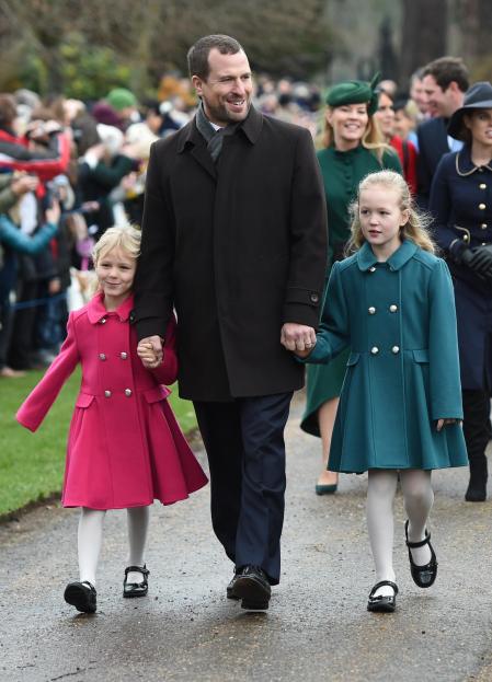 Peter Phillips junto a sus hijas Isla (izq.) y Savannah en su llegada a la tradicional misa de Navidad en Sandringham.