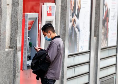 Persona saca dinero de un cajero automático en Madrid