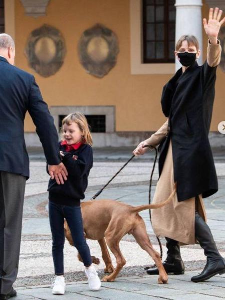 Charlene saluda a los medios mientras sujeta al nuevo miembro de la familia, Khan