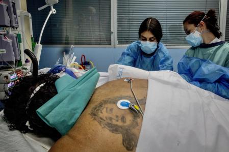 Un enfermo de covid en la uci del hospital de Sant Pau atendido por dos de las enfermeras de este servicio