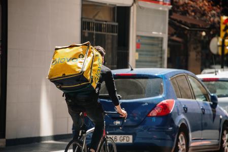 Un rider de Glovo realiza un reparto por una ciudad de España