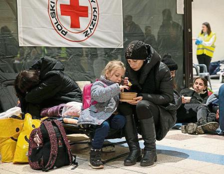 05 March 2022, Poland, Przemysl: A woman and a child eat inside a temporary reception area at a warehouse in Przemysl. Hundreds of thousands of Ukrainian refugees fled through the Medyka-Shehyni border following the Russian invasion of Ukraine. Photo: Hesther Ng/SOPA Images via ZUMA Press Wire/dpa Hesther Ng/SOPA Images via ZUMA / DPA 05/03/2022 ONLY FOR USE IN SPAIN