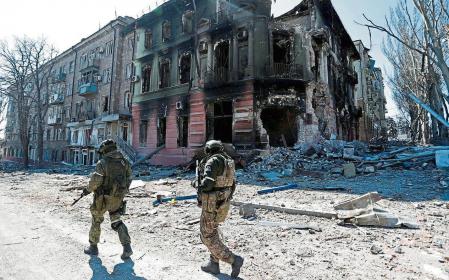FILE PHOTO: Service members of pro-Russian troops inspect streets during Ukraine-Russia conflict in the southern port city of Mariupol, Ukraine April 7, 2022. REUTERS/Alexander Ermochenko/File Photo