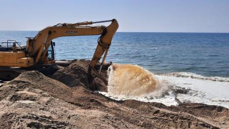 Trabajos de reposición de arena en la playa de Gavà.