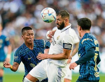 Real Madrid forward Karim Benzema (9) tries to get past América midfielder Pedro Aquino (5) during the first half of a friendly soccer match in San Francisco, Tuesday, July 26, 2022. (AP Photo/Godofredo A. Vásquez)