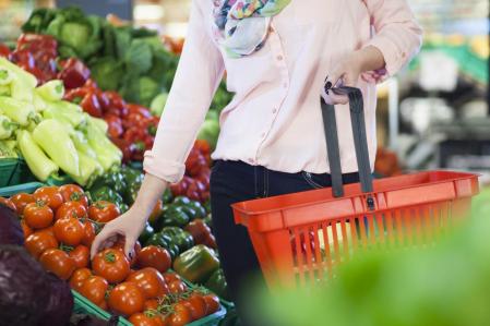 Mujer comprando tomate en el supermercado