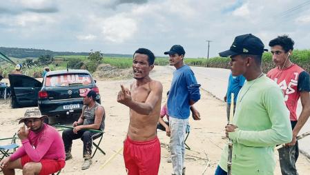 Trabajadores de caña de azúcar hablan sobre su jornada, durante una pausa, en las plantaciones de Alagoas, Brasil