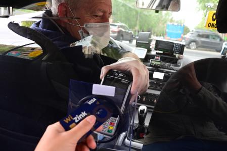 Un usuario pagando con una tarjeta de crédito en un taxi