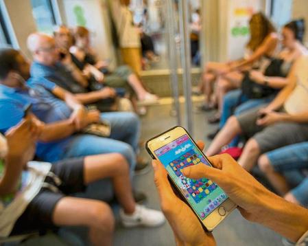 FOTO: MANÉ ESPINOSA. UNA JOVEN JUGANDO CON EL MÓVIL A CANDY CRUSH EN EL TREN