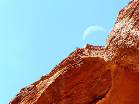 La luna menguante sobre la roca rojiza de Petra.