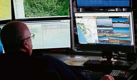 Cal Fire fire captain Kris Yeary views screens with dispatch logs and a view of some of the over 1,000 cameras with artificial intelligence (AI) technology powering the ALERTCalifornia wildfire camera network to help firefighters detect new fire starts from Cal Fire's San Diego County headquarters in El Cajon, California on September 6, 2023. When a wildfire erupted in the middle of a recent California night, it could have been a disaster. But thanks to a new monitoring system that uses artificial intelligence to scan for danger, firefighters were able to quell the blaze long before it got out of hand. (Photo by Patrick T. Fallon / AFP)