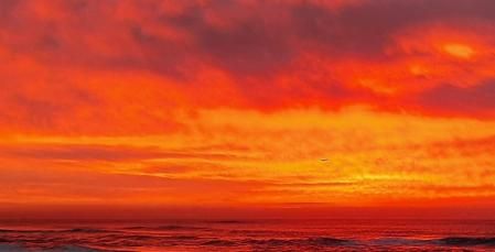 El avión atravesando un cielo de fuego frente a la costa de Gavà.