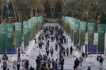 People walk through the COP28 U.N. Climate Summit, Monday, Dec. 4, 2023, in Dubai, United Arab Emirates. (AP Photo/Peter Dejong)