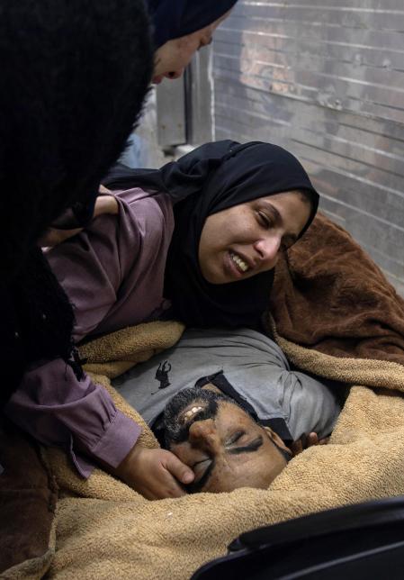 Khan Yunis (-), 04/01/2024.- The wife of one of the Palestinians from the Abu Hatab family, who was killed during an Israeli air strike that targeted tents of displaced people in areas classified by the Israeli army as safe in the southern Gaza Strip, mourns next to his wrapped body, inside the morgue of Nasser Hospital in Khan Younis, southern Gaza Strip, 04 January 2024. More than 22,300 Palestinians and at least 1,300 Israelis have been killed, according to the Palestinian Health Ministry and the Israel Defense Forces (IDF), since Hamas militants launched an attack against Israel from the Gaza Strip on 07 October, and the Israeli operations in Gaza and the West Bank which followed it. The Israeli military stated on 04 January that it conducted raids in Khan Yunis, as its ground, air, and naval troops are 'continuing to conduct joint combat' across the Gaza Strip. EFE/EPA/HAITHAM IMAD ATTENTION EDITORS: GRAPHIC CONTENT