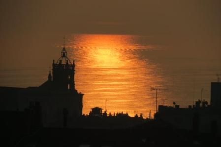 Pilar solar en el mar con la basílica de Santa Maria de Mataró.