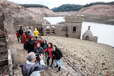 El turismo de sequía ha hecho que cada vez sean más los que visiten el pantano de Sau, que actualmente está a un 1'4% de su capacidad. No es extraño que visitantes, en un intento de acercarse lo máximo posible al agua, pongan los pies en zonas donde el barro está todavía muy blando y se hundan