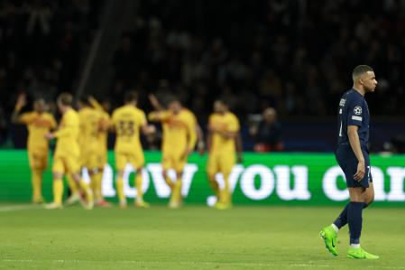 Los jugadores del Barça celebran un gol mientras Mbappé camina por el césped