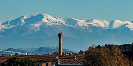La chimenea de la Fàbrica del Sucre, a la izquierda el Puigmal y a la derecha, los montes que rodean Vall de Núria.