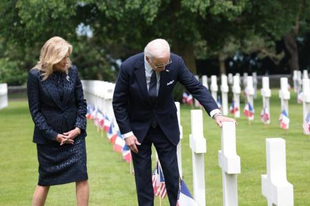 Biden y su esposa observan una de las cruces del camposanto, donde reposan más de 9.000 militares fallecidos durante la campaña de Normandía