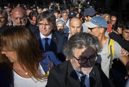 Carles Puigdemont reaparece a las nueve en punto de la mañana por la calle Sant Benet hasta la calle de Trafalgar, donde caminó envuelto por multitudes hasta el escenario situado a los pies del Arc de Triomf, el el Passeig Lluís Companys, después de 7 años en el exilio. Tras su intervención de cinco minutos, la organización del acto solicitó a los asistentes, 2.500 personas según los Mossos, la realización de una cadena humana que debía acompañar a Puigdemont y el resto de dirigentes políticos hasta el Parlament. Centenares de cámaras siguieron al político mientras descendía del escenario, donde se había colocado estratégicamente una especie de panel a modo de puerta. Ese panel blanco fue precisamente aprovechado por Puigdemont y los pocos que conocían el plan de fuga para salir por detrás del escenario y subirse inmediatamente en un coche blanco que le esperaba.