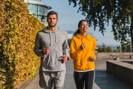 Un hombre y una mujer con sudadera practicando deporte.