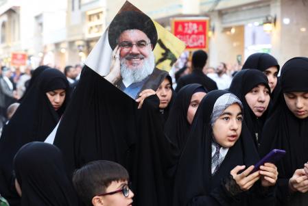 An Iraqi woman holds a picture of Lebanon's Hezbollah leader Sayyed Hassan Nasrallah, as she attends protest following the announcement of his death, in Najaf, Iraq, September 30, 2024. REUTERS/Alaa Al-Marjani
