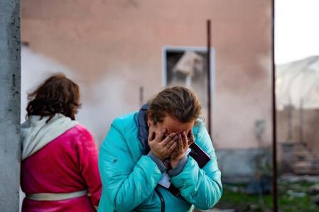 In this handout photograph taken and released by the Ukrainian Emergency Service on November 17, 2024, a woman reacts in the courtyard of a damaged building following a missile attack at an undisclosed location in Odesa region. Russia pounded Ukraine with 