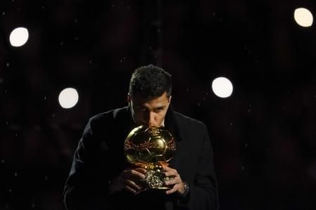 Manchester City's Rodri kisses off his Ballon d'Or (Golden Ball) award before the start of the English Premier League soccer match between Manchester City and Tottenham at the Etihad Stadium in Manchester, England, Sunday, Nov. 24, 2024. (AP Photo/Dave Thompson)