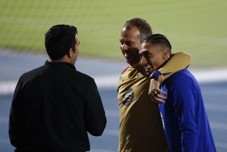 El entrenador del FC Barcelona, el alemán Hansi Flick (c) y el delantero brasileño Raphinha, durante el entrenamiento de este sábado en Yeda, en la víspera de la final de la Supercopa de España de fútbol que les enfrenta mañana domingo al Real Madrid.
